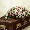 Pink roses and white lilies arranged on a casket