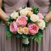 Bouquet of pink and cream roses with greenery