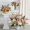 Pink lily and rose arrangements in white and gold containers