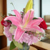 Pink lilies and red roses in a clear glass vase