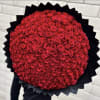 Large round bouquet of red roses wrapped in black paper