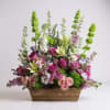 Hand selected flowers in rich purple,soft pink,and lush green tones arranged with