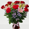 Bouquet of red roses and pink lilies in a glass vase