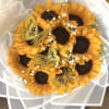 Bouquet of sunflowers wrapped in white paper with gold butterfly accents