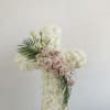 Cross-shaped floral arrangement of white and blush roses on an easel