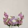 Pink and lavender roses arranged in a white ribbed vase