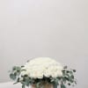 White rose arrangement in a woven basket with eucalyptus