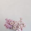 Pink roses and white orchids arranged in a white box