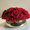 Red roses arranged in a low gold bowl