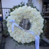 White floral wreath on an easel with a ribbon
