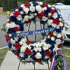 Red, white, and blue floral wreath on a stand with a ribbon