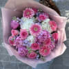 Bright pink roses and cheerful gerbera daisies create an immediate burst of