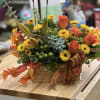 Autumn floral arrangement with orange roses and yellow daisies in a wooden box