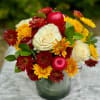Bouquet of white roses and red-yellow chrysanthemums in a glass vase