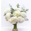 White hydrangea bouquet in a clear glass vase with eucalyptus