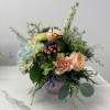 Mixed bouquet of peach and pale blue flowers in a vase