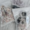 Assorted packaged candles with dried flower pieces and crystal accents