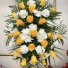 Yellow roses and white chrysanthemums in a tall standing arrangement