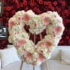 Heart-shaped floral arrangement with pink gerberas, roses, and white hydrangeas