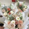 Three pastel mixed flower bouquets wrapped in white paper