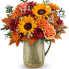 Autumn bouquet of sunflowers, roses, and mums in a metal pitcher