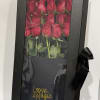 Boxed arrangement of red roses with a black ribbon