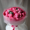 Pink rose bouquet wrapped in translucent paper with a ribbon
