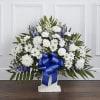 White floral standing spray with a blue ribbon on a pedestal base