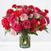 Pink roses and red carnations in a clear glass vase