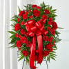 Red rose and carnation standing wreath with a large red ribbon
