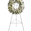 White floral wreath on a black standing easel