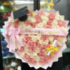 Heart-shaped bouquet of pink and white roses with a graduation cap topper
