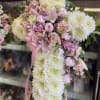 Pink and white floral standing spray with ribbon on an easel