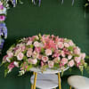 Large pink floral arrangement with roses and lilies on a round table