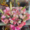 Pink and white bouquet with lilies and roses wrapped in pink paper