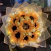 Bouquet of orange sunflowers and white roses wrapped in translucent paper