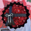 Bouquet of red roses wrapped in black paper with a pearl bow