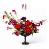 Mixed red and pink floral arrangement in a black pedestal bowl