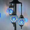 Three mosaic glass table lamps with blue light on a metal stand
