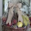 Wrapped fruit basket in a wicker container with a beige bow
