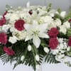 White lilies and pink carnations arranged in a casket spray