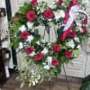 Heart-shaped standing easel adorned with roses and a mix of flowers for