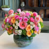 Pink and peach mixed flower arrangement in a clear glass vase