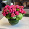 Pink peonies and green hydrangeas in a round glass vase