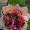 Bouquet of pink and red roses with yellow sunflowers in pink wrap