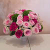 Pink and magenta roses arranged in a white vase