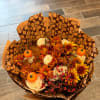 Bouquet of orange and white flowers with small pumpkin accents in patterned wrap