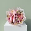 A delicate blend of soft pink roses, gerbera daisies, and seasonal blooms