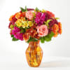 Mixed bouquet of roses, chrysanthemums, and alstroemeria in an amber glass vase