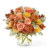 Bouquet of orange and yellow flowers in a clear glass vase